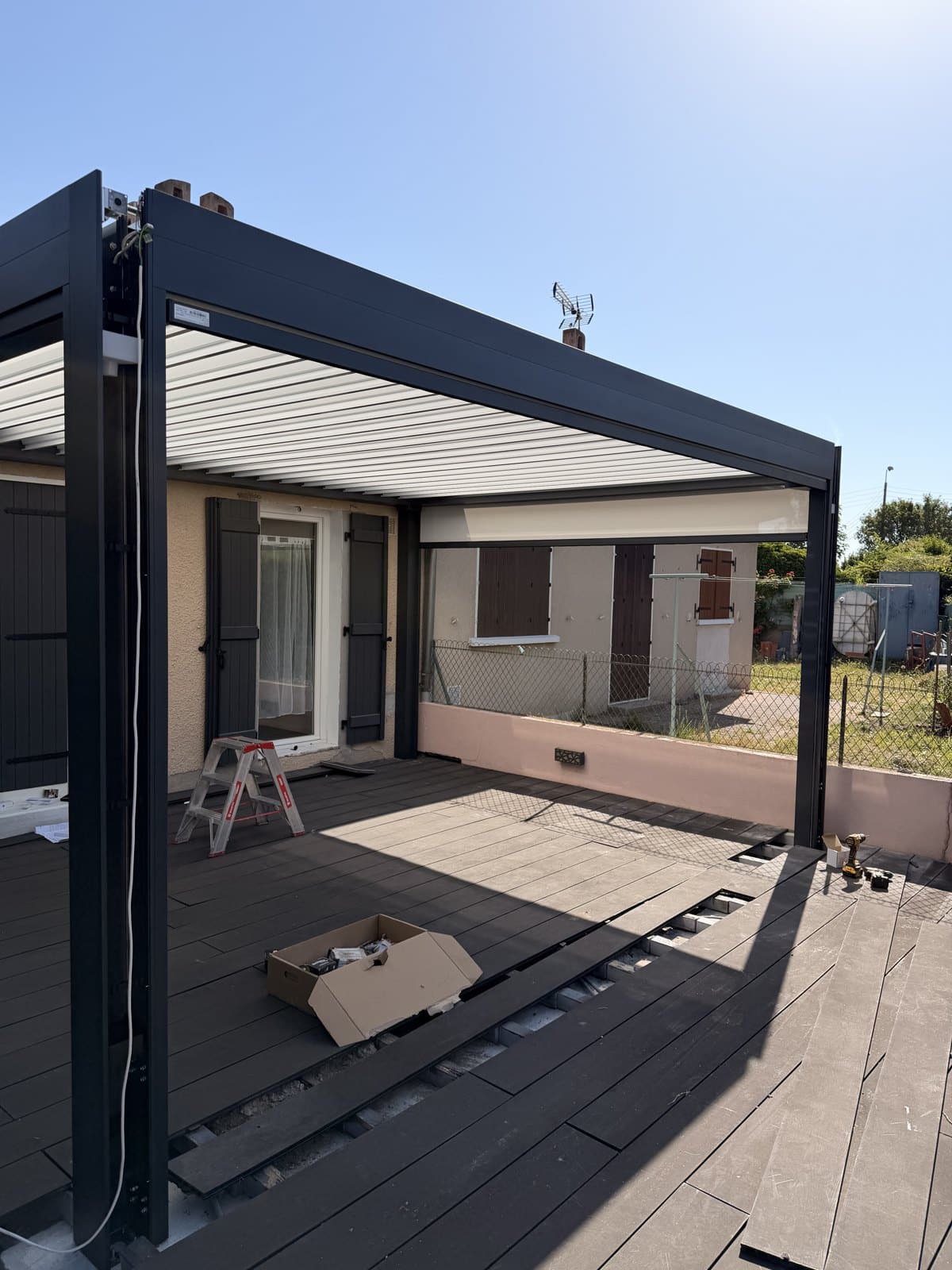 Pose d'une pergola bioclimatique Marquises aluminium anthracite à Cournon-d'Auvergne par Top Fermetures