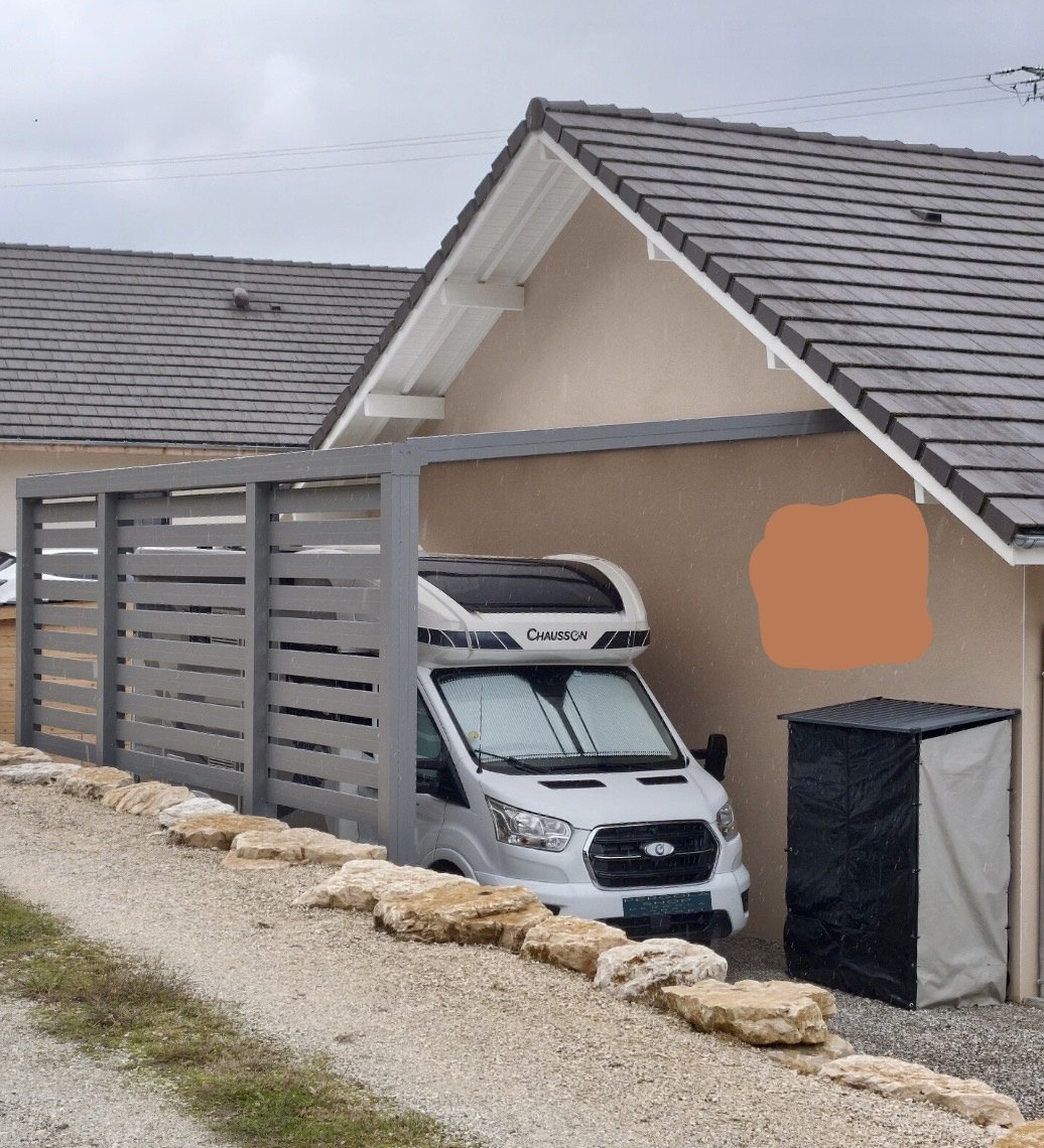 Carport aluminium Skylux avec claustra ajouré vu de la rue — abri camping-car par Top Fermetures